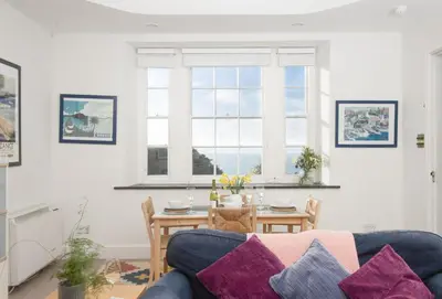 a living room with a blue couch and a table at Acton Castle in Praa Sands