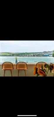 three chairs sitting on a balcony looking out at the ocean at 3 Bed Stylish Beachfront Retreat in Roche
