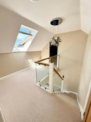 an attic room with a skylight and a window at Porth Beach Lodge in Saint Columb Minor