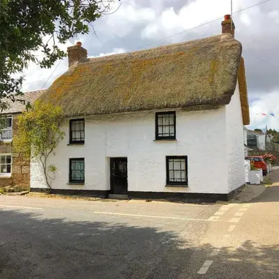 an old white building with a thatched roof at Harvest Cottage in Constantine