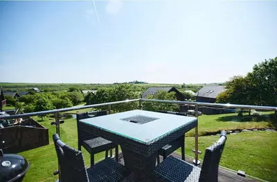 a table and chairs on the balcony of a house at Sunrise in Saint Columb Major