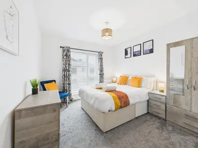 a bedroom with a king sized bed and a mirror at Beachside Retreat by Signature Stays - Modern Coastal Home in Hayle