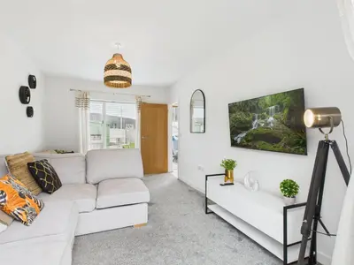 a living room with a white couch and a tv at No4 Harveys Yard By Signature Stays - Luxury Stay - Beach - Parking in Hayle