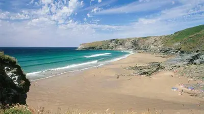 a beach with people on the sand and the ocean at 3 Bed in Tintagel oc-e32938 in Tintagel