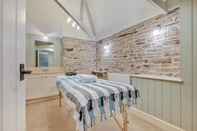 a bathroom with a bed and a stone wall at 8 Bed in Tresillian oc-t32986 in Newlyn East