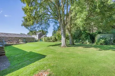 a large yard with a tree and a bench at 6 Bed in Tresillian oc-t32987 in Newlyn East