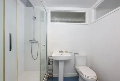 a bathroom with a toilet and a sink and a shower at The Gatehouse Apartment in Portreath