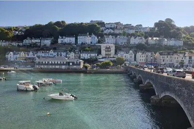 a boat in the water next to a bridge at Looe Cottage - Seaside views log fire sleeps 4 in Looe