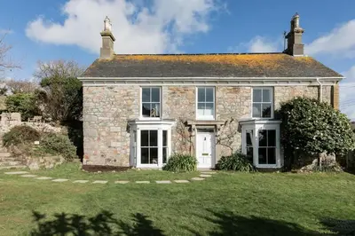 an old stone house with a green yard at Grade II Listed 17th-Century Rectory in Cornwall in Perranuthnoe