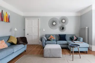 a living room with two blue couches and a table at Grade II Listed 17th-Century Rectory in Cornwall in Perranuthnoe