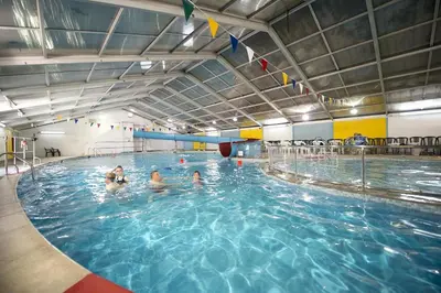 a group of people swimming in a swimming pool at Finest Retreats - Joyful Cottage in St Ives