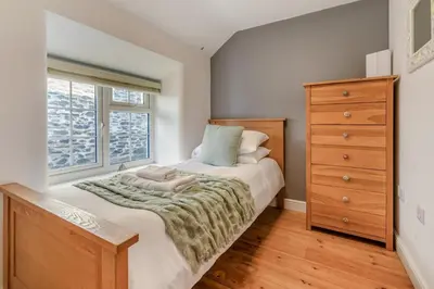 a bedroom with a bed and a dresser and a window at 3 Bed in Sithney oc-cpv110 in Carleen
