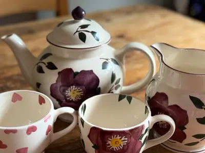 a table with two cups and a tea pot at Buddleia Cottage Trewoon, St Austell in St Austell