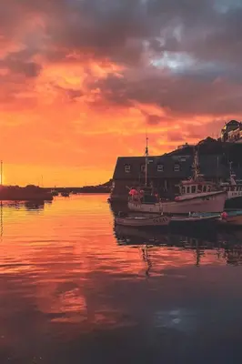 a group of boats sitting in the water at sunset at Holiday Home Tregony House 2 Bedrooms by Interhome in Mevagissey