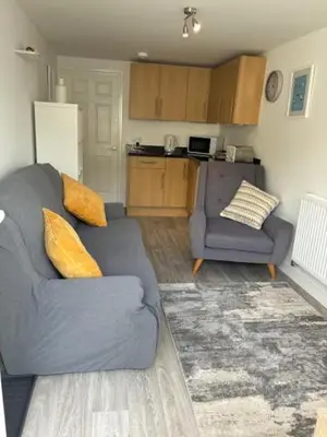 a living room with a blue couch and a kitchen at Park Rd in Redruth