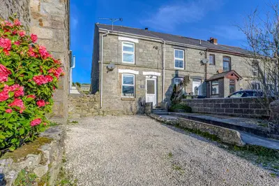 an old stone house with flowers in front of it at Danny Cottage in Saint Dennis