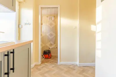 a kitchen with a door leading into a room with a closet at Danny Cottage in Saint Dennis