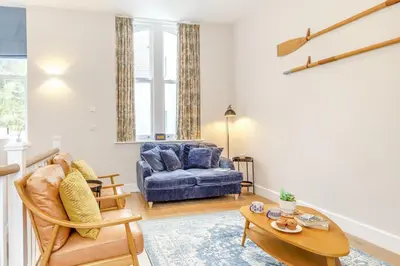 a living room with a blue couch and a table at 2 Bed in Fowey oc-n33435 in Fowey