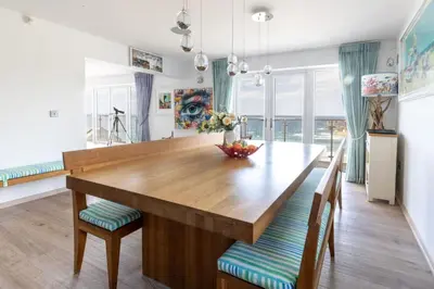 a dining room with a wooden table and chairs at Tides Edge in Portreath