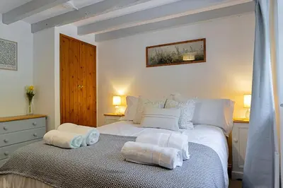 a bedroom with a white bed with towels on it at Finest Retreats - Rowella Cottage in Blisland