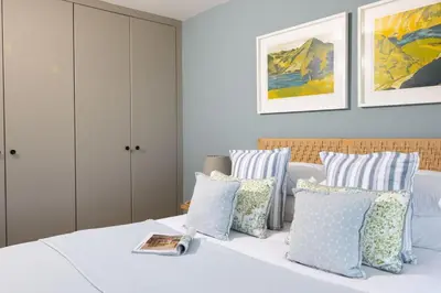 a bedroom with blue and white pillows on a bed at Tamarind Tide in Portreath
