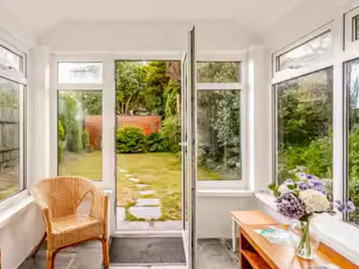 a bathroom with a tub and a table and windows at Sunnyside Cottage Retreat in St Austell