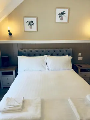 a large white bed with two towels on it at Rising Sun Inn - Rough Tor in Altarnun