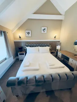 a bedroom with a large bed with two pillows on it at Rising Sun Inn - Kil Margh in Altarnun