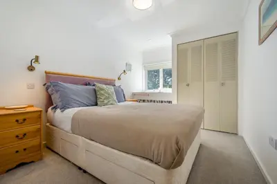 a bedroom with a large bed and a wooden dresser at 5 Bed in Trebetherick oc-t33296 in Polzeath
