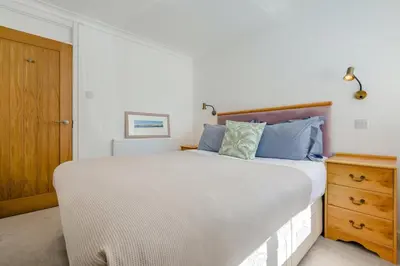 a bedroom with a large bed and a wooden door at 5 Bed in Trebetherick oc-t33296 in Polzeath