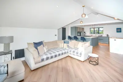 a living room with two white couches and a kitchen at 5 Bed in St. Ives oc-c28961 in Saint Ewe