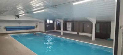 a swimming pool in a building with a person in it at Peace Haven in Par