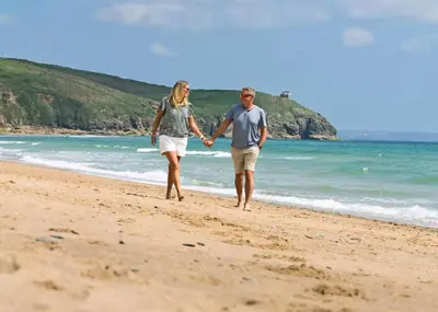 a man and woman walking on the beach at Praa Sands Holiday Park in Praa Sands