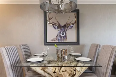 a dining room table with a deer head painting on the wall at Crystal View, Compass Point - Sea View - Free WiFi & Parking - Close to Beach in Carbis Bay