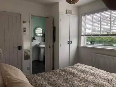 a bedroom with a bed and a sink and a window at Num 29 in Newquay