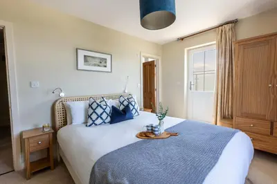 a bedroom with a bed with a tray on it at Sunset Sands in St Merryn