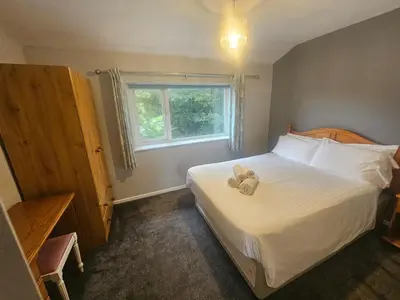 a bedroom with a bed with a teddy bear on it at Newquay Coast and Cabin in Saint Columb Road Station