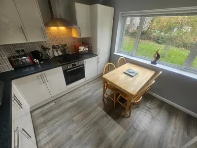 a kitchen with a wooden table and a dining room at Newquay Coast and Cabin in Saint Columb Road Station