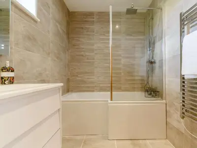 a bathroom with a shower and a white tub at 3 Bed in Saltash oc-88525 in Landrake