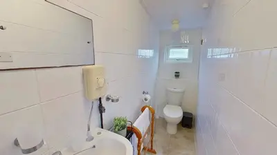 a white bathroom with a toilet and a sink at D17 Vellanoweth, Riviere Towans in Hayle