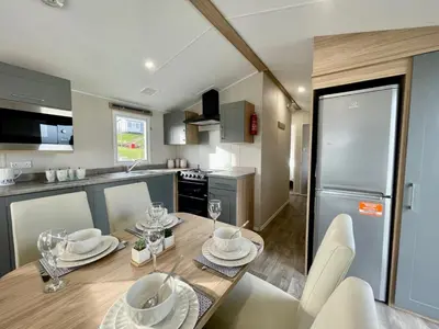 a kitchen with a wooden table with plates and glasses on it at Polperro Seaside Retreat in Polperro