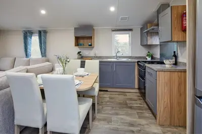 a kitchen and living room with a table and chairs at Polperro Seaside Retreat in Polperro