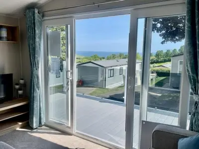an open sliding glass door with a view of a yard at Polperro Seaview Retreat in Polperro
