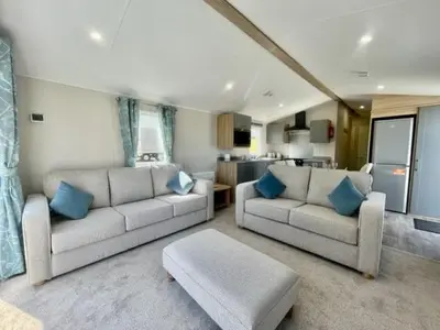 a living room with two couches and a kitchen at Polperro Seaview Retreat in Polperro