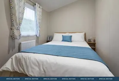 a bedroom with a large bed with a blue pillow at Polperro Seaview Retreat in Polperro
