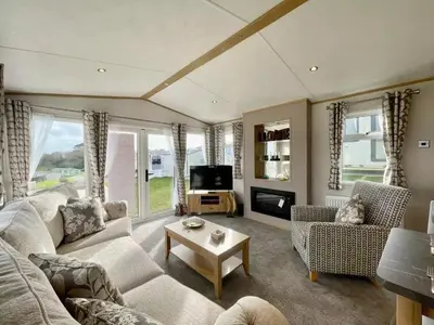 a living room with a couch and a tv at Polperro Seaview Lodge in Polperro