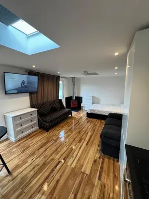 a living room with a couch a bed and a tv at Private Retreat Hot Tub Fire Pit Patio Romantic in Morval