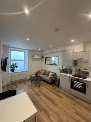 a living room with a couch and a kitchen at 1 Bed Apartment in Town Centre in Newquay