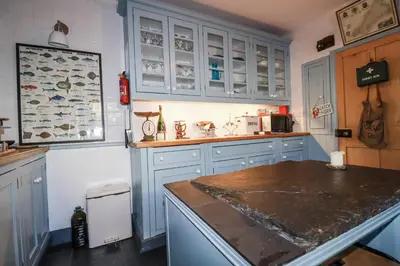a kitchen with blue cabinets and a counter top at Rosedale in St Ives