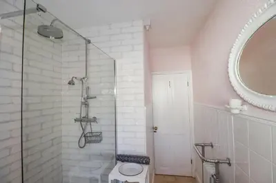 a bathroom with a shower with a toilet and a mirror at Rosedale in St Ives